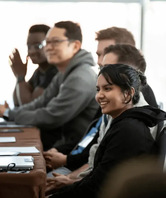 Prisma team members smiling and engaged during an indoor workshop